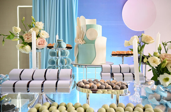modern light blue birthday cake with macarons tower, elegant dessert table arrangement at luxury event, wedding candy buffet catering presentation, beautiful flowers decoration close up