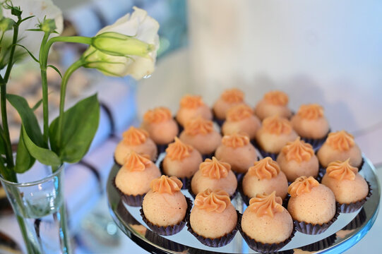 gourmet brigadeiro sweets with dulce de leche piping, elegant wedding candy presentation on glass stand, luxury dessert catering event buffet, delicious confectionery close up