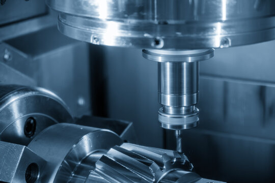 Macro shot of a bevel gear shaft part being cut by a ball nose end mill tool on a multi-tasking CNC machine.