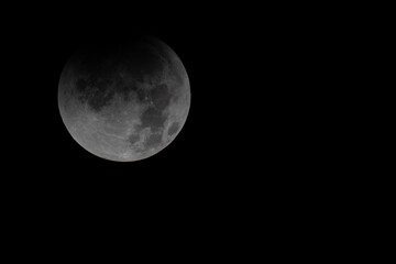Fototapeta premium Partial lunar eclipse beginning with Earth's shadow covering the moon / 地球の影が月を覆い始めた皆既月食の始まり