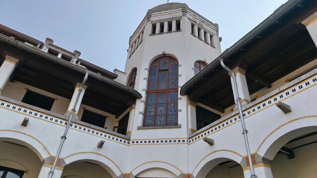Low angle view of the iconic Lawang Sewu historical building in Semarang, Indonesia, showcasing magnificent Dutch colonial architecture with large stained glass windows, classic white corridors