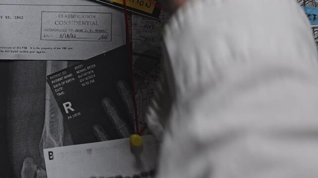 Close-up of a detective tying red string between evidence on a crime board, visualizing investigative reasoning, clue analysis, and suspenseful crime storytelling.