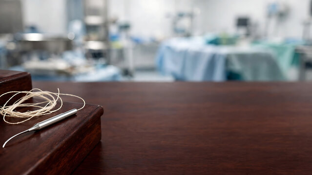 Professional Medical Surgical Instruments on Wooden Table with Blurred Hospital Operating Room Background