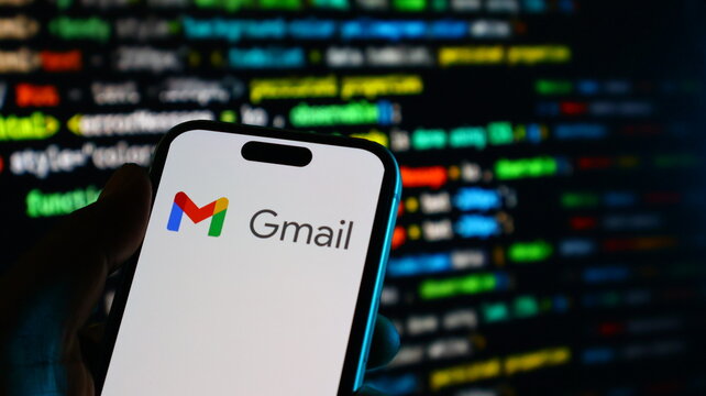 Smartphone displaying gmail app on screen with coding background