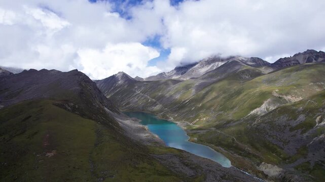 Drone view of Baimalincuo and Zhegong three lakes in Mount Kula Kangri in sunny cloudy day, well-built hiking trail circling its shore. 4k real time footage travel concept b roll shot.