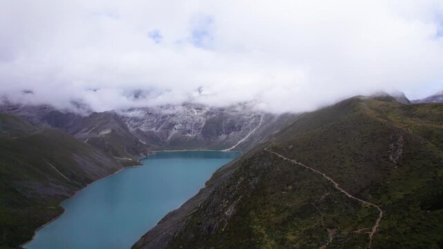Drone view of Baimalincuo and Zhegong three lakes in Mount Kula Kangri in sunny cloudy day, well-built hiking trail circling its shore. 4k real time footage travel concept b roll shot.
