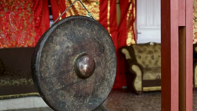 A traditional hanging gong suspended in place, showcasing the cultural and ceremonial heritage of Indonesian traditional music and ritual practices.