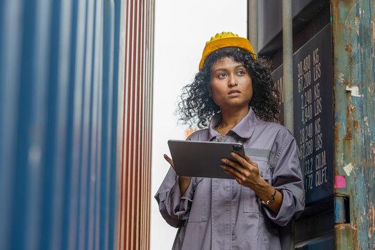 Female Engineer with Digital Tablet Inspecting Cargo Container at Port Terminal, Woman Worker Examining and Checking Inventory Documentation Shipping Box Exterior