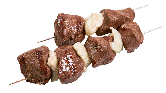 Raw beef cubes and onion pieces threaded onto metal skewers, isolated on transparent background