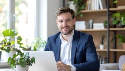 Fototapeta premium Successful Businessman at Desk with Laptop in Bright Office Workspace