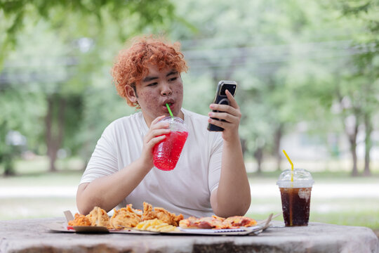 Gen Z Teen Drinking Sugary Soft Drink While Using Smartphone &ndash; Junk Food Lifestyle and Digital Generation Concept