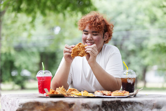 Happy Gen Z Teen Eating Fried Chicken Outdoors &ndash; Junk Food Lifestyle, Fast Food and Unhealthy Eating Habit