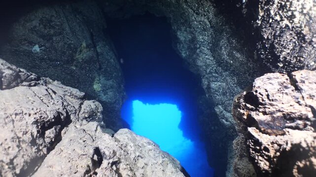 cave diving underwater scuba divers exploring caves and having fun ocean scenery sun beams and rays background