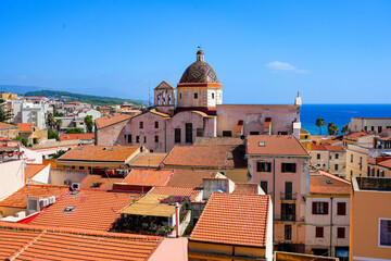 Fototapeta premium Panoramic view of the historic town rooftops and the colorful dome of the Church of Saint Michael the Archangel (Chiesa di San Michele Arcangelo) in Alghero, Sardinia, Italy