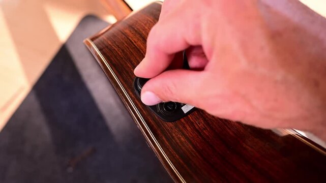 Luthier assembling an electric acoustic guitar preamp