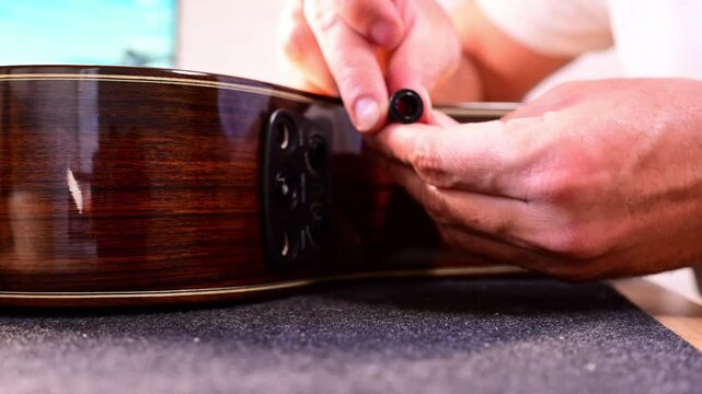 Close-up of guitar maker installing an electronic pickup