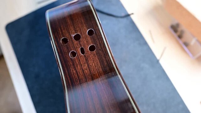 Close-up of a new acoustic guitar building process in a luthier workshop