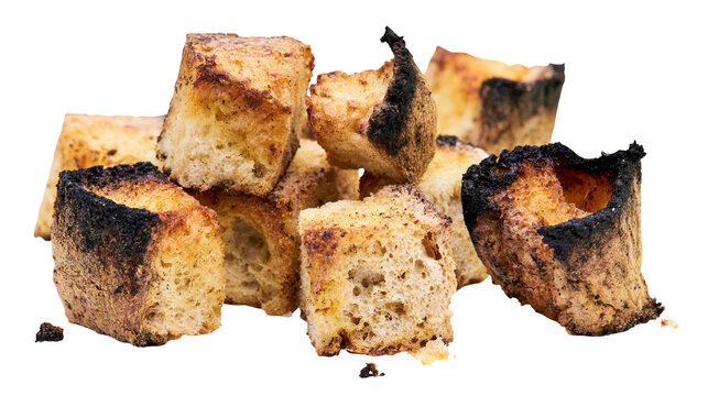 Burnt bread cubes with dark charred edges, isolated on transparent background