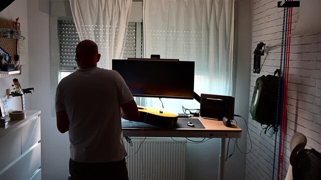 Man learning to play guitar with online lessons at home