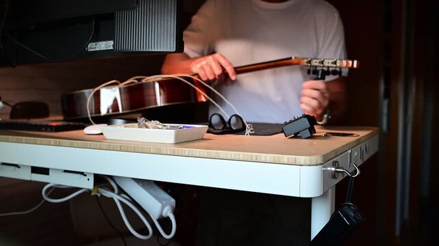 Man changing strings on his acoustic guitar