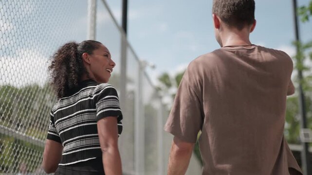female pickleball player is walking and talking to her coach about training programs and competition schedules, as well as how to maintain her physical condition in preparation for practice on field..