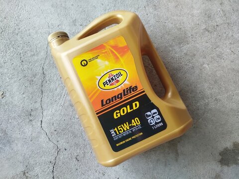 KUALA TERENGGANU MALAYSIA- JULY 10.2026: A large 7-liter gold plastic jug of Pennzoil LongLife Gold SAE 15W-40 heavy-duty motor oil sitting on a concrete floor.