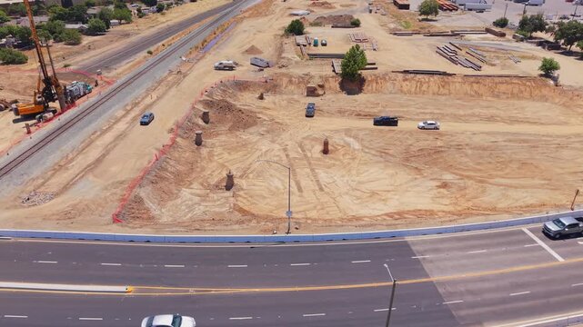 Panning Aerial Drone Shot Left to Right Over California High Speed Rail Construction With Railroad Crossing Manholes Heavy Machinery and Traffic