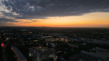 Obraz premium City skyline at sunset with dramatic clouds and urban landscape visible