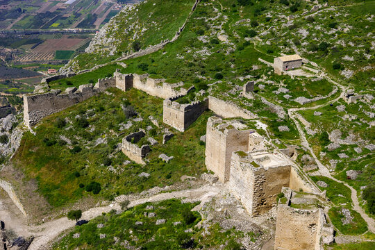 Aerial view of the ancient ruins of Acrocorinth, a fortress overlooking the Corinthian Gulf in Greece, showcasing its extensive walls and towers.