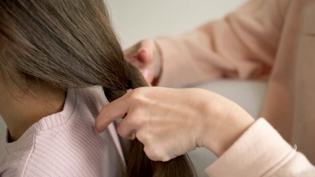 Mother braiding her young daughter's hair