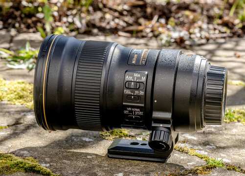 Gothenburg, Sweden - April 21 2024: Professional Nikon telephoto lens resting on stone surface outdoors.