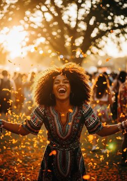 Joyful Black Woman Celebrating at Outdoor Festival with Falling Petals During Golden Hour Sunset