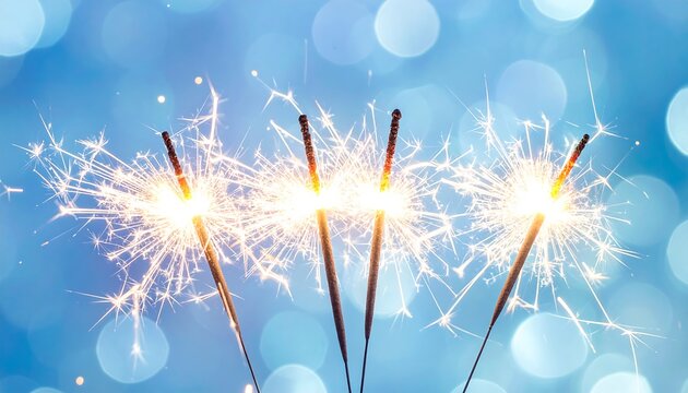 Bright Sparkler Sticks Glowing Against Blue Bokeh Background