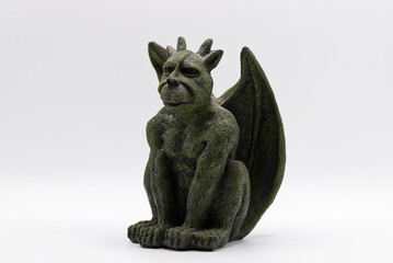 Fototapeta premium Green stone gargoyle statue with wings and horns isolated on a white background.