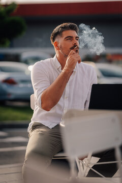 Man smoking cigarette feeling pensive outdoors