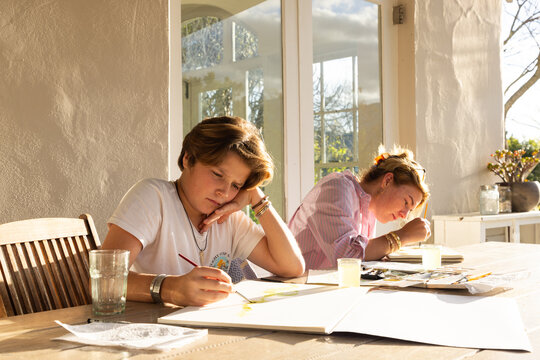 female art instructor with her student outdoors doing watercolor paintings