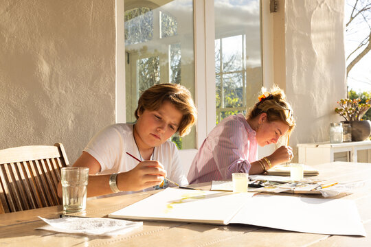 female art instructor with her student outdoors doing watercolor paintings
