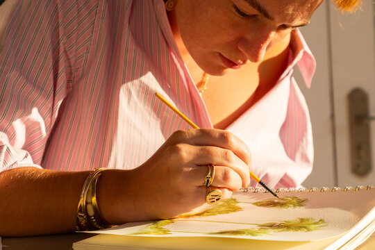close up of woman artist doing watercolor painting outdoors