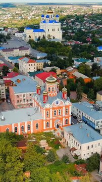 Vertical video. Yelets, Lipetsk region, Russia. Church of the Archangel Michael, a five-cupola Orthodox cathedral with gilded domes and salmon-pink walls, Drone footage over the historic city center.