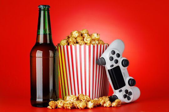 Popcorn and gamepad on red background