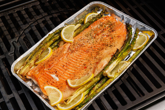Grilled salmon fillets and asparagus sizzling on a barbecue grill