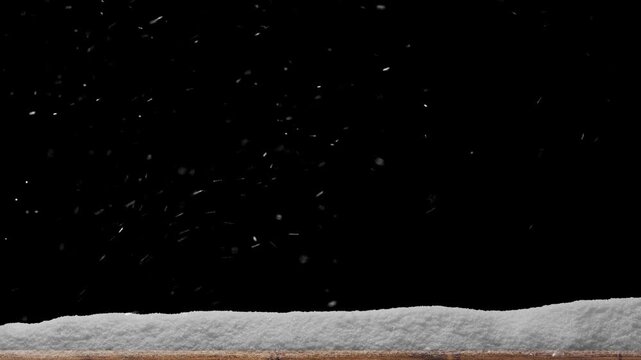 Snow falls on a wooden floor with a pile of snow