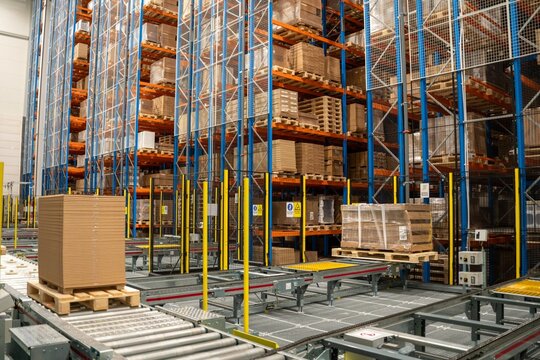 Automated warehouse pallet conveyor and ASRS inbound system with high bay storage racks for efficient logistics, material handling and distribution center operations