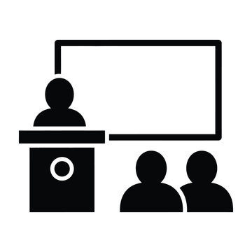 Presenter at podium speaking to audience in front of blank screen