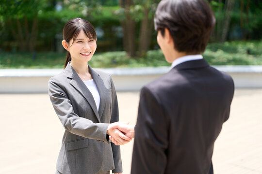 握手をするアジア人ビジネスパーソン