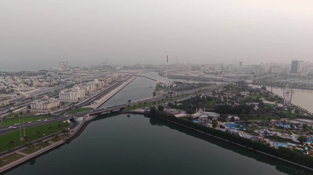 Cinematic Aerial Drone shot of Sharjah at early morning golden hour, UAE Flag, Sharjah Skyline and Sharjah Corniche in the background