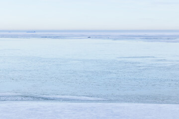 Naklejka premium A tranquil winter seascape showing a vast frozen sea and distant horizon in pale blue tones. Smooth ice, subtle texture and serene atmosphere convey cold, stillness and minimalist coastal beauty