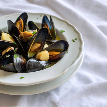 Clotchina  de Castell&oacute;n Mejillones cocidos en salsa con ajo y perejil servidos en un plato hondo blanco
