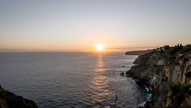 Coastal Serenity at Sunset: A breathtaking vista of a rugged coastline meeting the vast ocean, illuminated by the golden hues of a setting sun casting a shimmering path across the water.