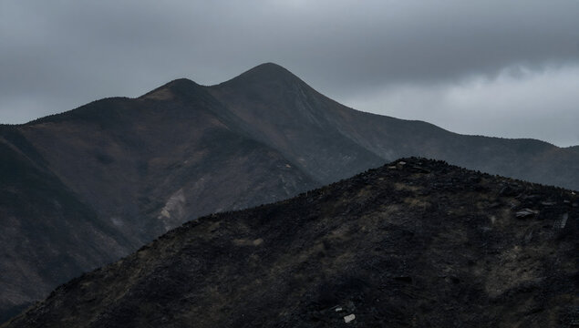 Ominous Peaks Under Cloudy Sky: Dramatic mountain range under a heavy, overcast sky, creating a sense of foreboding and natural power.